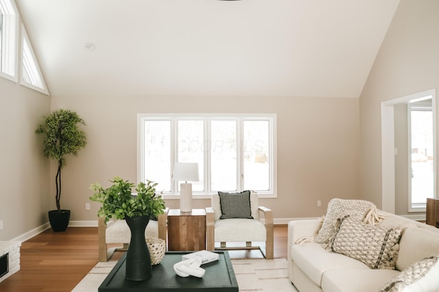 living room with vaulted ceiling, light wood-type flooring, and a healthy amount of sunlight