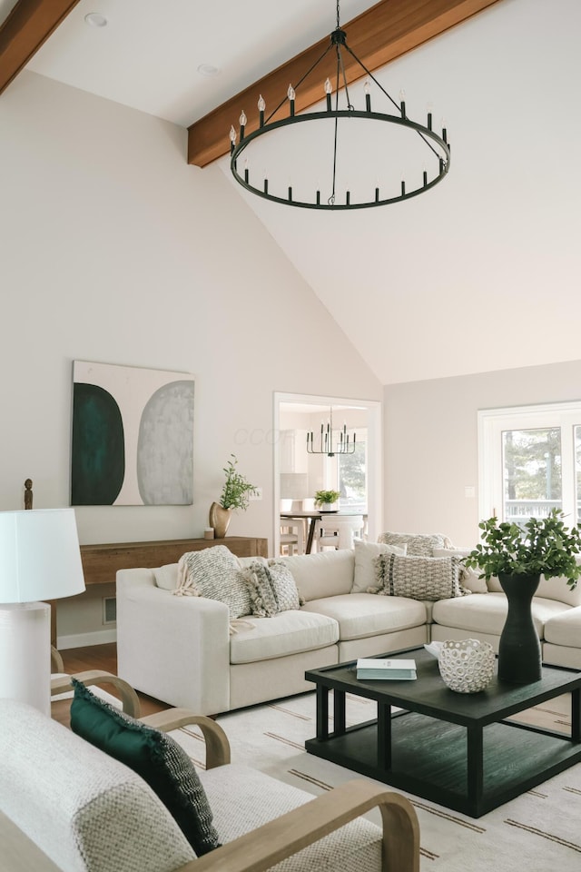 living room with high vaulted ceiling, beamed ceiling, and an inviting chandelier