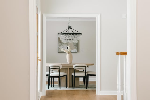 dining area featuring a notable chandelier, baseboards, and wood finished floors