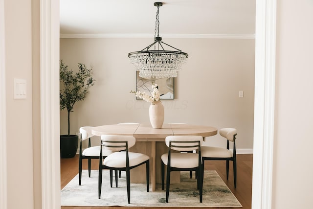 dining room featuring crown molding, baseboards, and wood finished floors