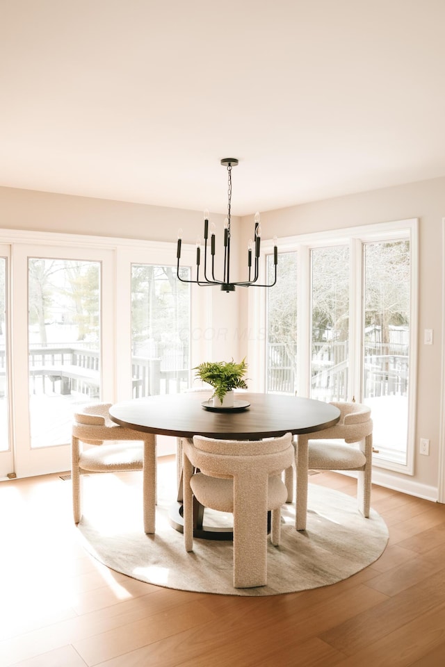 dining room with breakfast area, a notable chandelier, and light wood-style floors