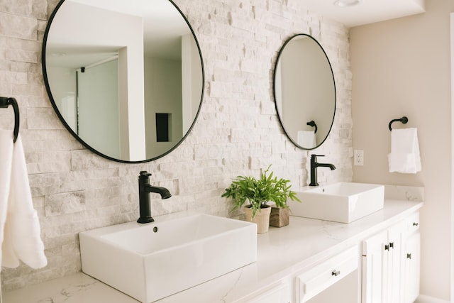 bathroom featuring double vanity, marble finish floor, and a sink