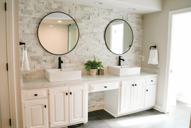 full bath featuring double vanity, tile patterned flooring, decorative backsplash, and a sink