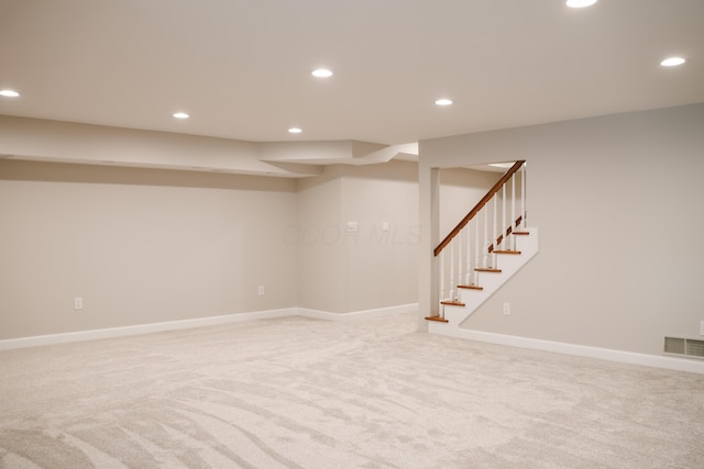 finished below grade area with recessed lighting, light colored carpet, visible vents, baseboards, and stairs