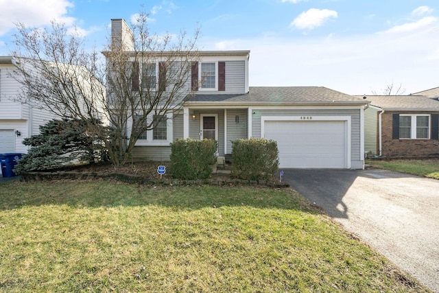 traditional-style house with a front yard, driveway, a chimney, and an attached garage