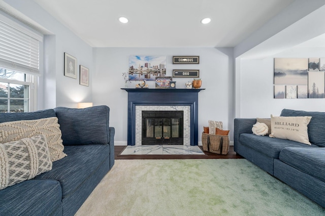 carpeted living room with a premium fireplace, baseboards, and recessed lighting