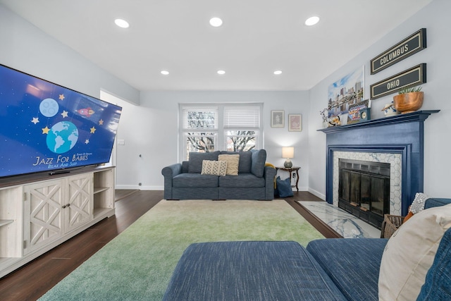 living area with baseboards, a fireplace, dark wood finished floors, and recessed lighting