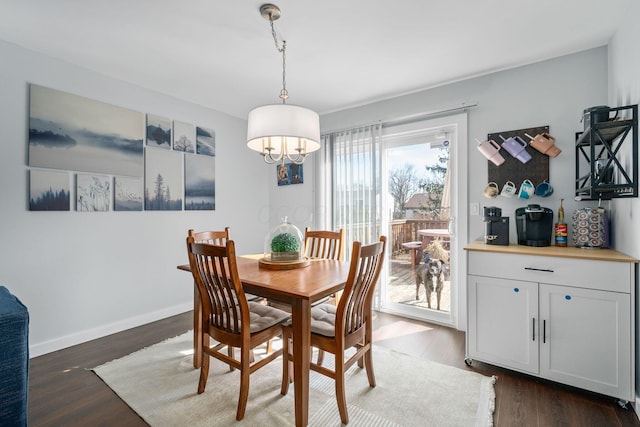 dining space featuring dark wood-style flooring and baseboards