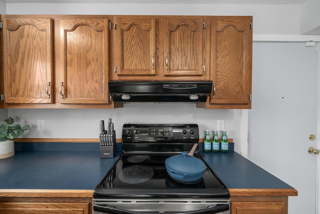 kitchen featuring black range with electric stovetop, brown cabinets, and under cabinet range hood