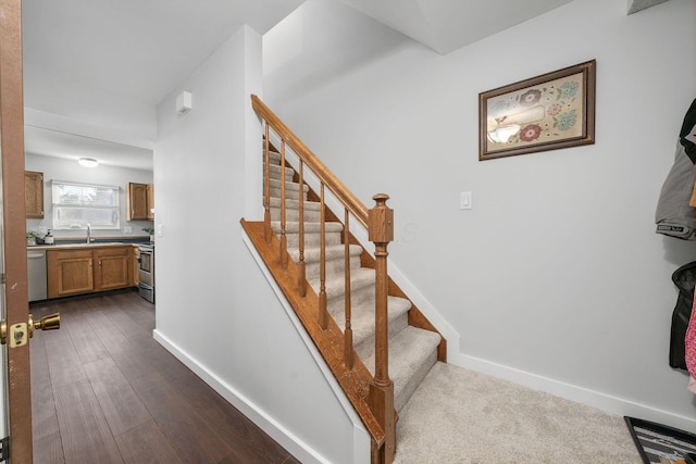 stairway with wood finished floors and baseboards