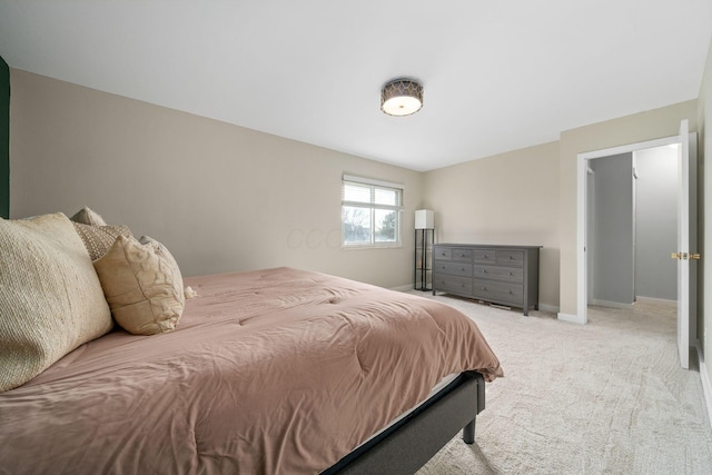 bedroom with baseboards and light colored carpet