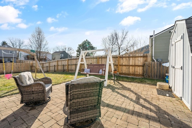 view of patio with a hot tub, a storage shed, a fenced backyard, and an outdoor structure