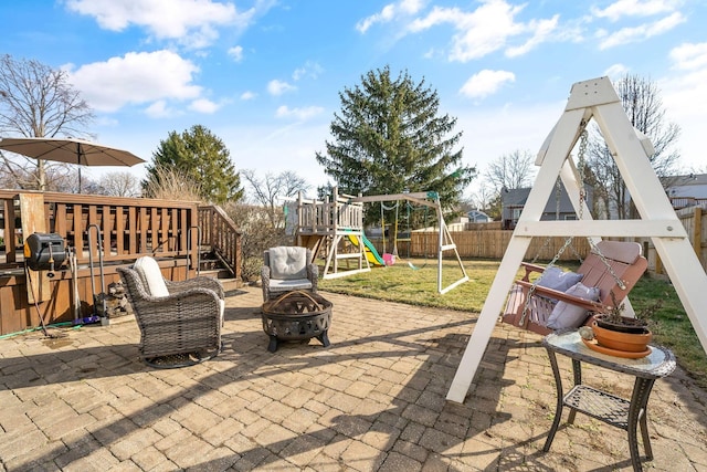 view of patio / terrace featuring a fire pit, a playground, and fence