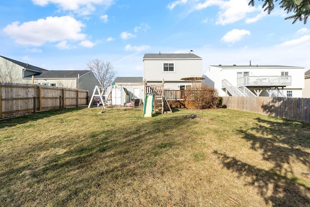 back of house with a fenced backyard, a lawn, a playground, and a shed