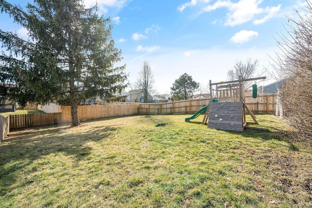 view of yard with a fenced backyard and a playground