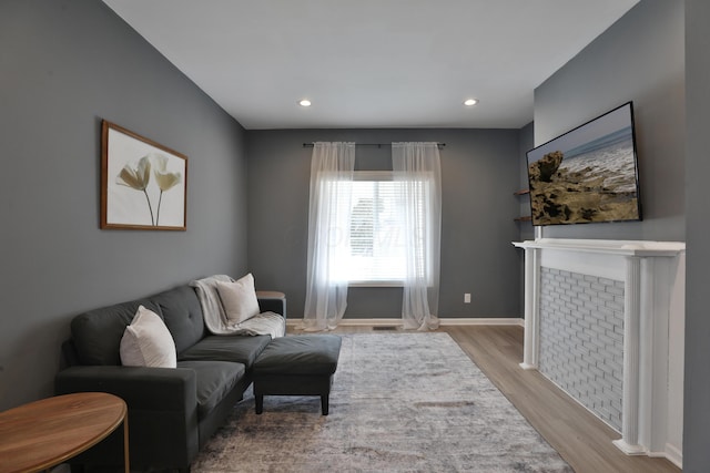 living room featuring light wood-style flooring, visible vents, baseboards, and recessed lighting