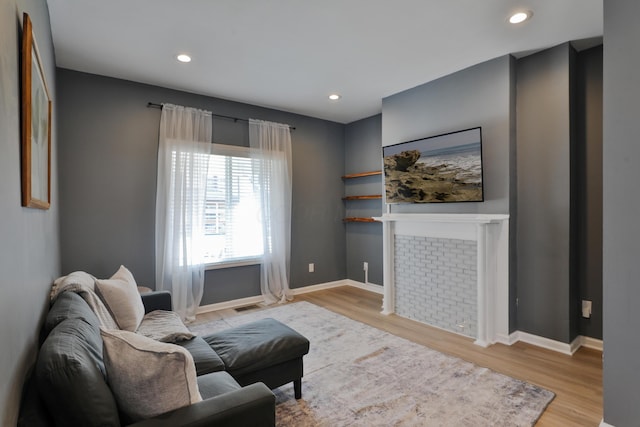 living room featuring baseboards, recessed lighting, and light wood-style floors