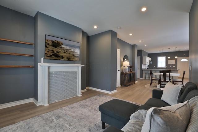 living area with light wood-style floors, baseboards, and recessed lighting