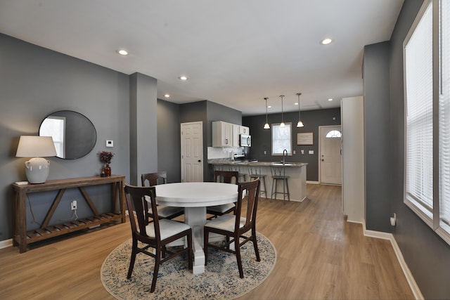 dining room featuring recessed lighting, light wood-style flooring, and baseboards