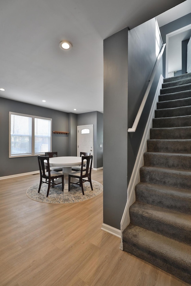 dining room with stairs, recessed lighting, baseboards, and light wood-style floors