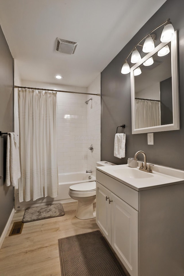 bathroom featuring toilet, visible vents, wood finished floors, and vanity