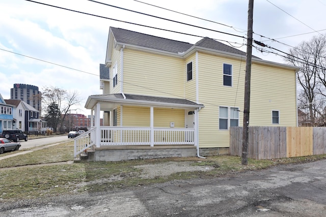 view of front of home with covered porch and fence