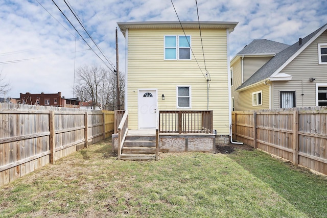 rear view of house featuring a fenced backyard and a yard