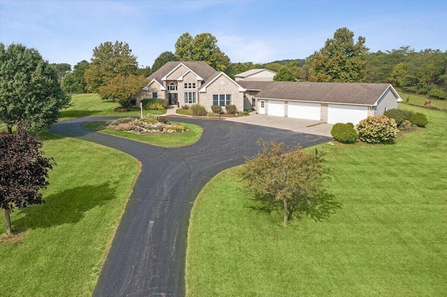 view of front of house featuring a garage, driveway, and a front yard