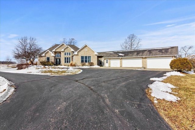 view of front of property featuring stone siding and aphalt driveway