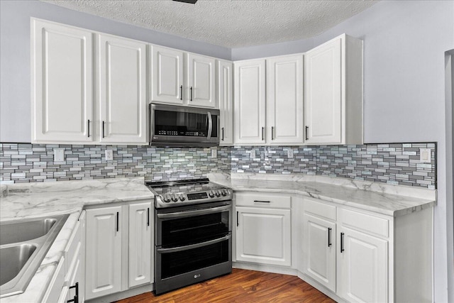 kitchen featuring stainless steel appliances, a sink, and white cabinets