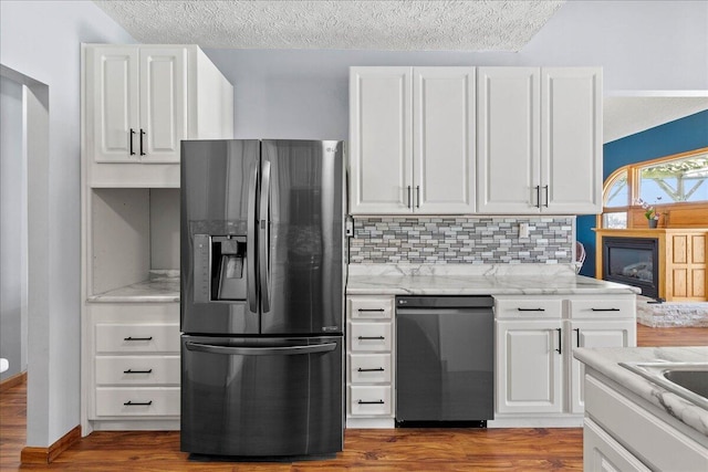 kitchen with black dishwasher, white cabinets, decorative backsplash, light stone countertops, and stainless steel refrigerator with ice dispenser