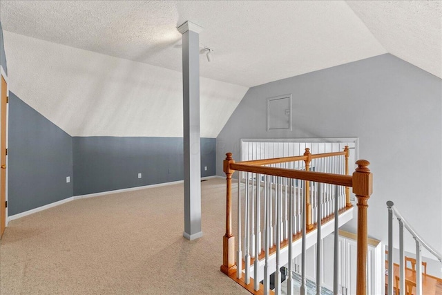 bonus room with carpet, baseboards, vaulted ceiling, and a textured ceiling