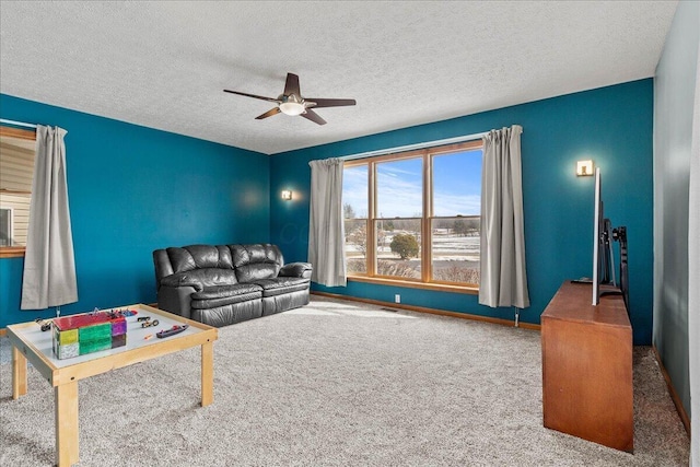 carpeted living room featuring a ceiling fan, a textured ceiling, and baseboards