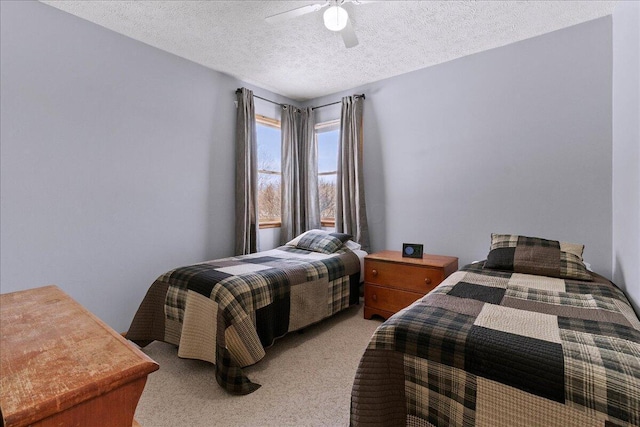 bedroom featuring light carpet, a textured ceiling, and a ceiling fan