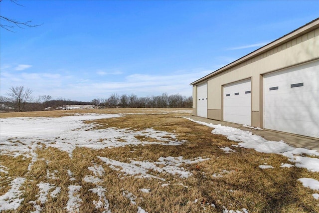 snowy yard with a garage