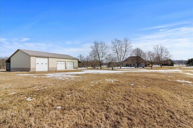 view of yard featuring a garage and an outdoor structure