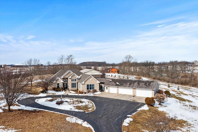 view of front facade with stone siding and aphalt driveway