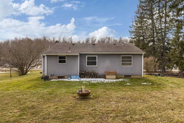 back of property featuring central air condition unit and a lawn