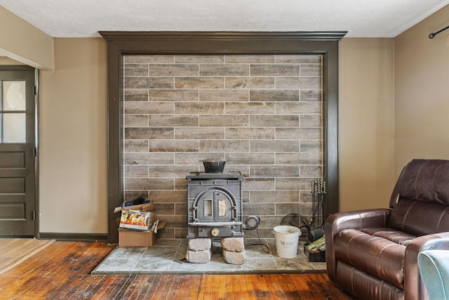 living room featuring dark wood-style floors, a wood stove, and a textured ceiling