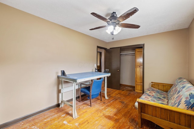 office space featuring ceiling fan, wood-type flooring, and baseboards