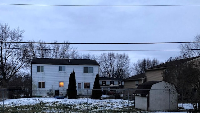 view of front of home featuring an outbuilding, a shed, and fence