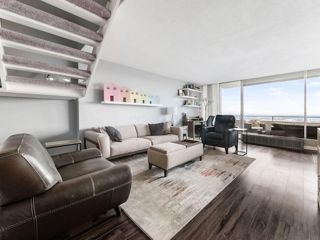 living area with radiator heating unit, dark wood finished floors, and floor to ceiling windows