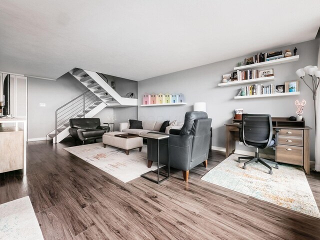 living room with stairway, wood finished floors, and baseboards