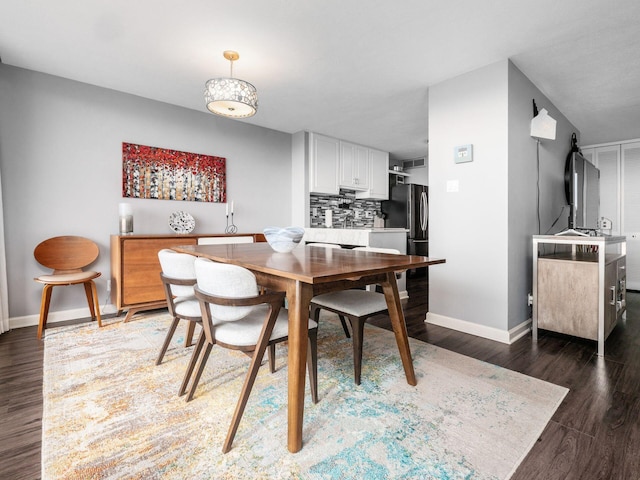 dining space featuring dark wood-style floors and baseboards