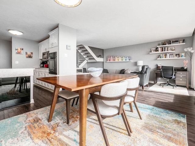 dining area with dark wood-type flooring and stairway