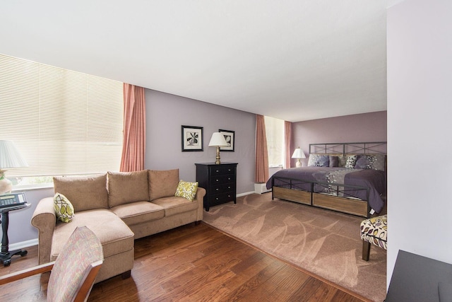 bedroom featuring multiple windows, baseboards, and wood finished floors