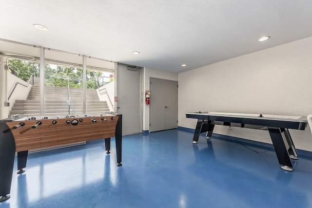 game room featuring finished concrete floors, recessed lighting, and a textured ceiling