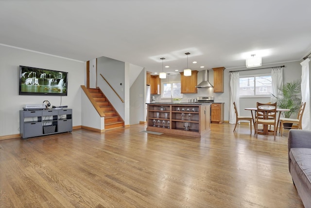 living room featuring ornamental molding, stairway, plenty of natural light, and light wood-style flooring