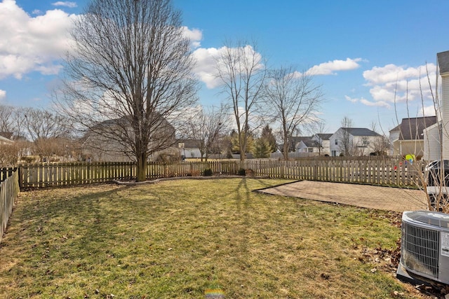 view of yard featuring a fenced backyard, a residential view, and central air condition unit