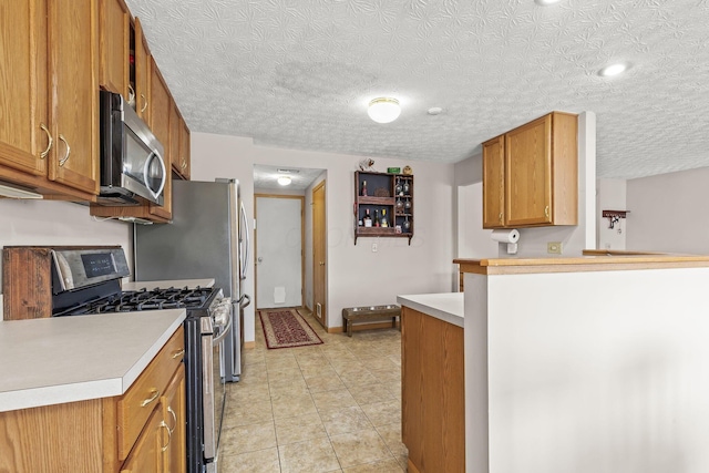 kitchen featuring light tile patterned floors, stainless steel appliances, a peninsula, light countertops, and brown cabinetry